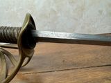 a close up of a sword on a wooden table