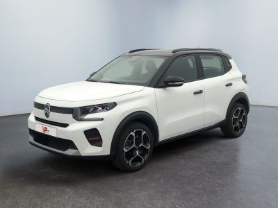 a white car is parked in a room with a black floor