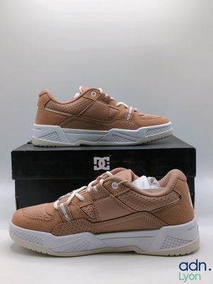 a pair of tan sneakers sitting on top of a box