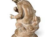an image of a statue of a boy sitting on a rock