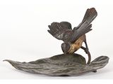 statue d'un oiseau perché sur une feuille, sur fond blanc