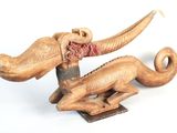 a wooden sculpture of an elephant with a red scarf