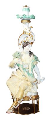 a statue of a woman sitting on a chair with a lamp on top of it