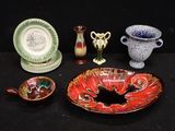 many pieces of pottery sitting on a black table