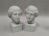 pair of white marble busts of two women with curly hair