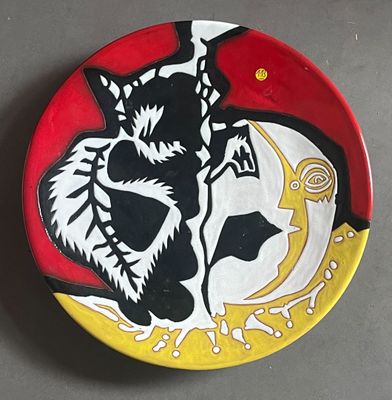 a plate with a painting of a cat and a bird on it