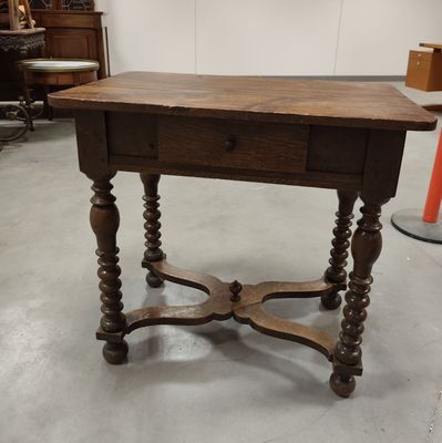a small table with a drawer on it in a room