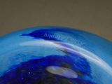 a blue glass vase with a blue swirl on it