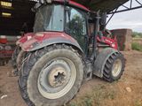 a red tractor that is parked in a barn