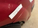 a close up of a red car with a sticker on it