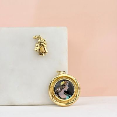 une photo d'une serrure dorée sur laquelle figure le portrait d'une femme