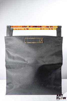sac en cuir noir muni d'une poignée et d'une poignée en bois sur fond blanc