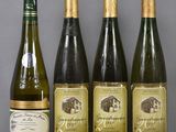 four bottles of wine are lined up on a table
