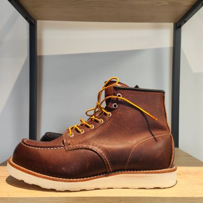 une paire de bottes Red Wing posée sur une étagère en bois