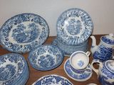 many blue and white plates and cups on the table