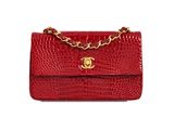a red crocodile skin bag with a gold chain