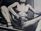 photographie en noir et blanc d'une femme nue assise sous un porche