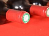 several bottles of red wine are lined up on a red table