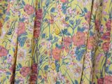 a close up of a yellow floral shirt with pink flowers on it