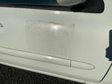 une voiture blanche qui a été repeinte en blanc et qui présente un trou sur le côté de la portière