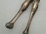 une paire de cuillères anciennes en argent posées sur une surface blanche