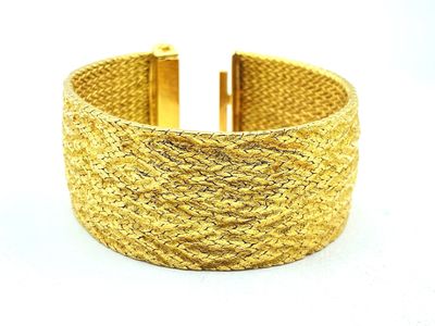 a close up of a gold bracelet on a white background