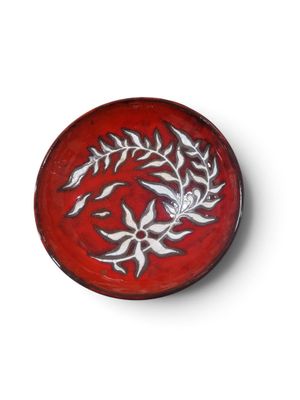 une assiette rouge ornée d'un motif sur fond blanc
