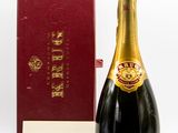 une image représentant une bouteille de champagne à côté d'une boîte rouge