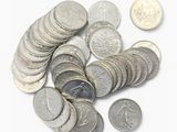 une pile de pièces de monnaie posée sur une surface blanche
