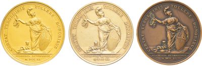 trois médailles d'or sur lesquelles figurent l'image d'une femme et celle d'un homme