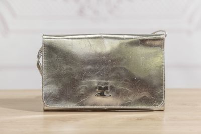 un sac à main en argent posé sur une table en bois
