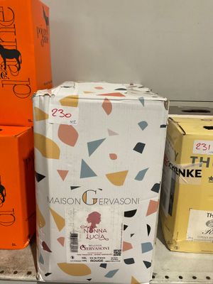 Plusieurs cartons de vin sont empilés sur une étagère dans un magasin.