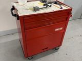 une boîte à outils rouge sur laquelle sont posés des outils
