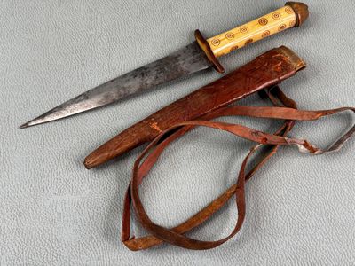 a knife and a leather sheath on a table