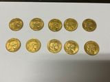 a bunch of gold coins sitting on top of a white table