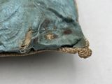 a blue pillow with a heart on it on a white surface