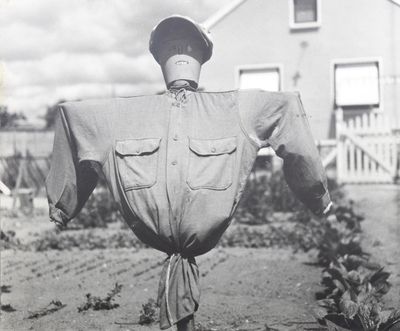 une vieille photo en noir et blanc montrant une effigie debout dans un champ