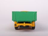 a green and yellow toy truck on a white surface