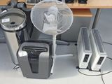 a fan sitting next to a desk with a computer on it