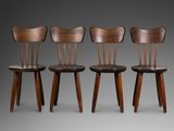 trois chaises en bois disposées côte à côte sur une surface grise