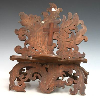une croix en bois posée sur une étagère en bois