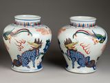 pair of chinese vases with dragon designs on them on a gray surface