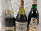 three bottles of wine are lined up on a white surface