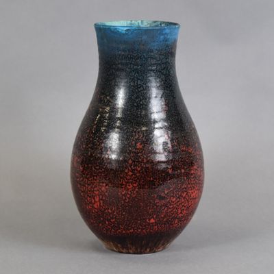 un vase rouge et bleu posé sur une table