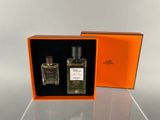 an orange box containing two bottles of perfume sitting on top of a table