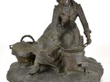 une statue représentant une femme assise sur un rocher avec un chien