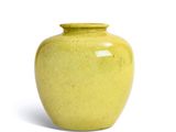 a yellow vase that is sitting on a white surface