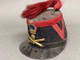a small hat with a red feather on top of it