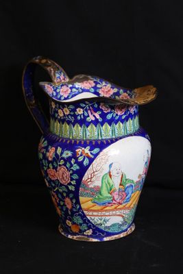un vase bleu orné d'un oiseau sur fond noir