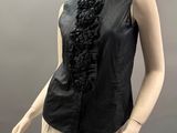 mannequin wearing a black shirt and tan pants with a black ruffle